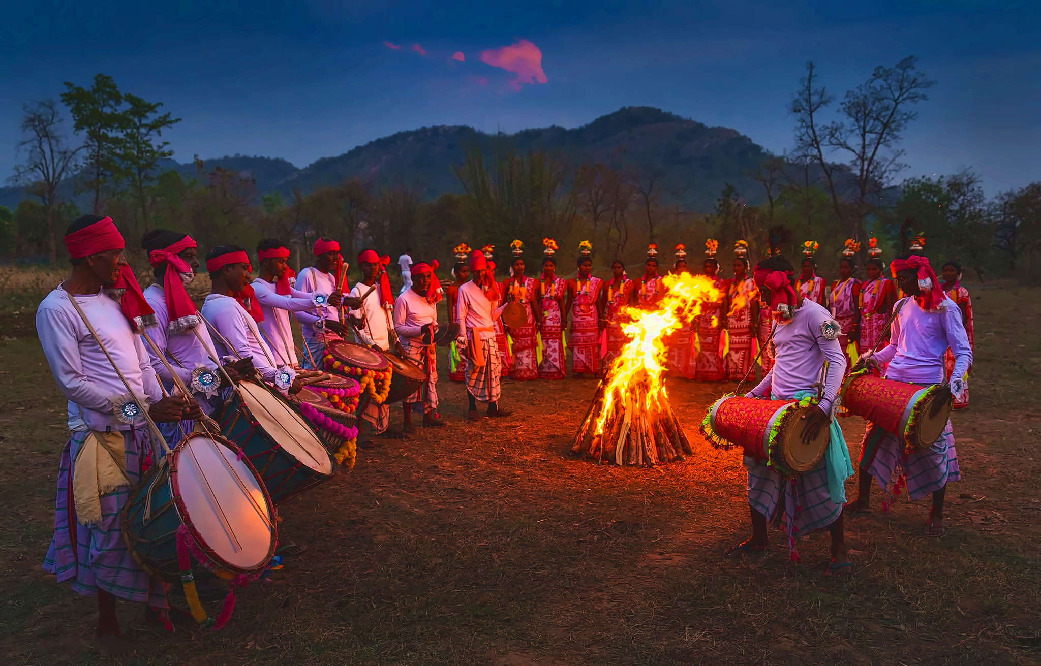 A community gathering around a bonfire with music and dance